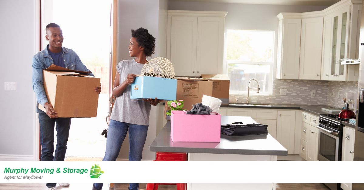 couple moving boxes into kitchen