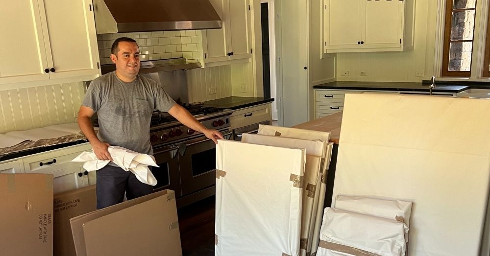 A mover stands with packed art in a kitchen for a move in Hartford.