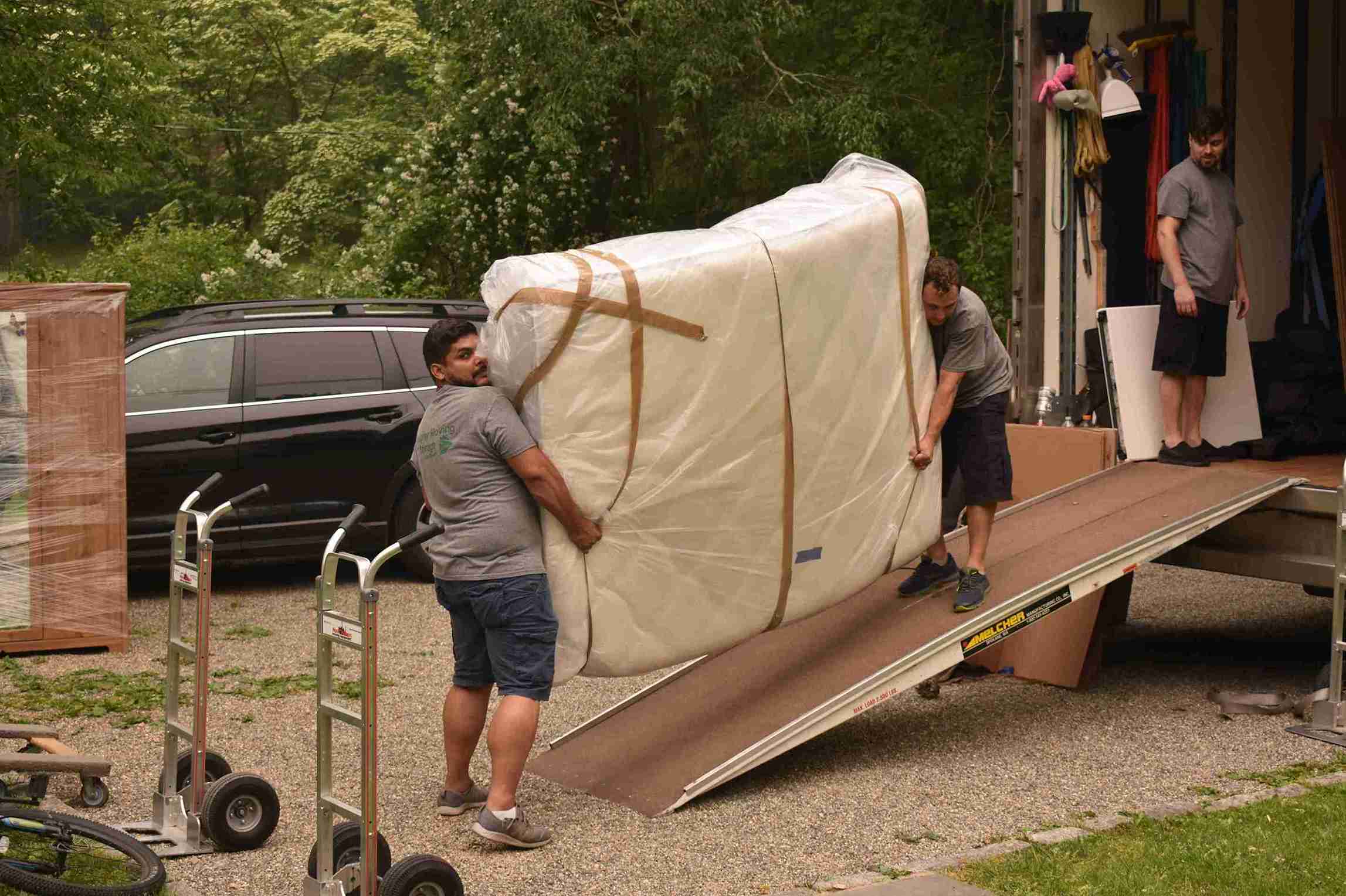 2 persons loading an item to the moving truck