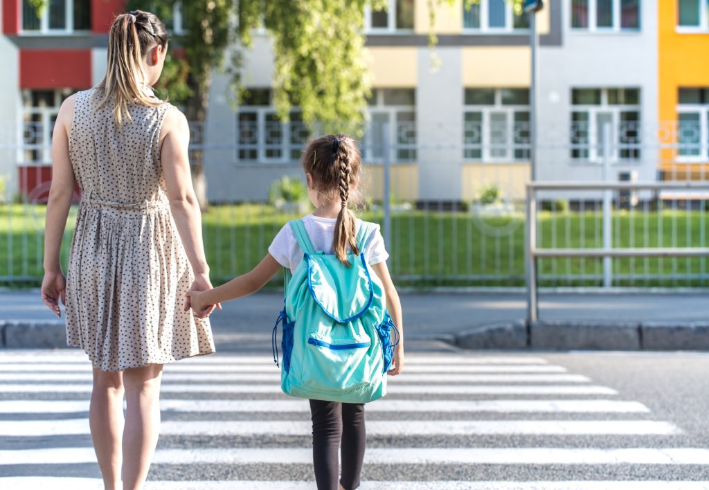 Back to school education concept with girl kids, elementary students, carrying backpacks going to class