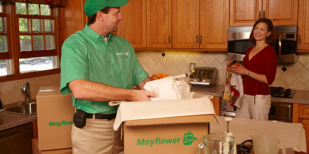 A professional moving technician in a green Mayflower shirt