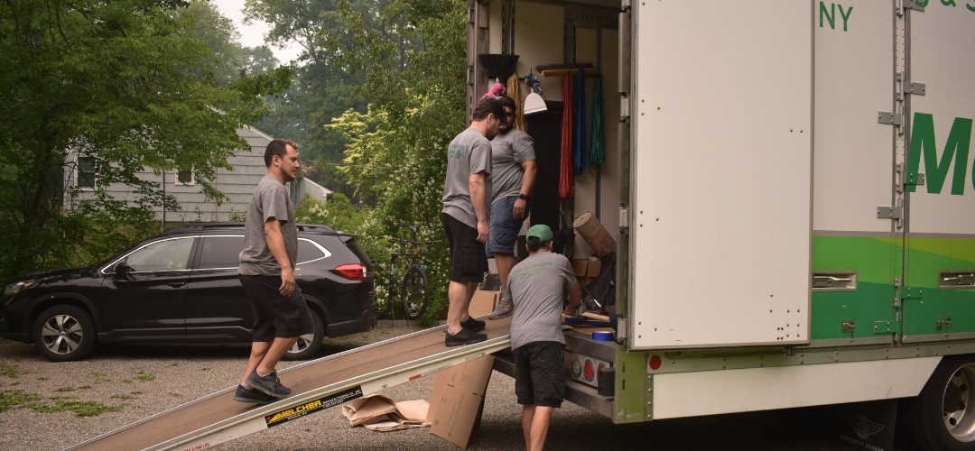 several movers in gray t-shirts unloading items