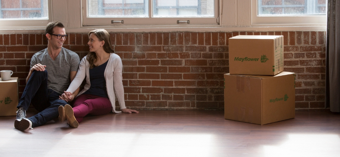 young couple sitting on the floor of an empty room