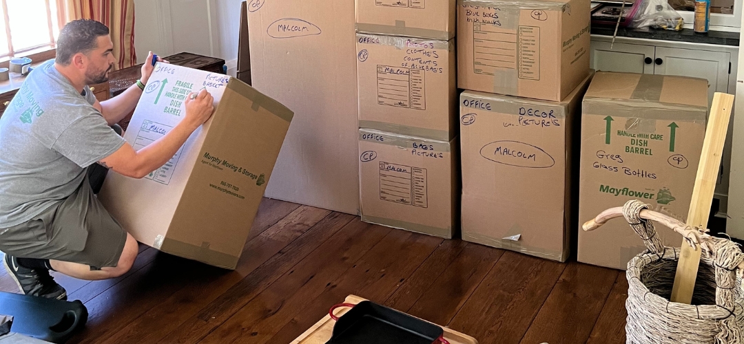 A man labeling cardboard boxes