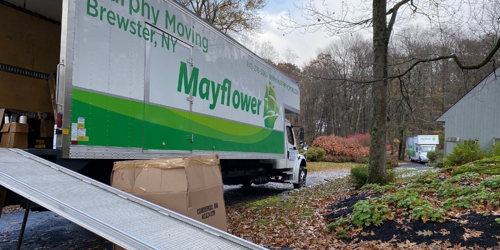 A white Mayflower moving truck parked in a driveway