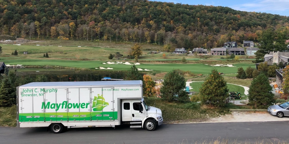 A white Mayflower moving truck parked on a roadside