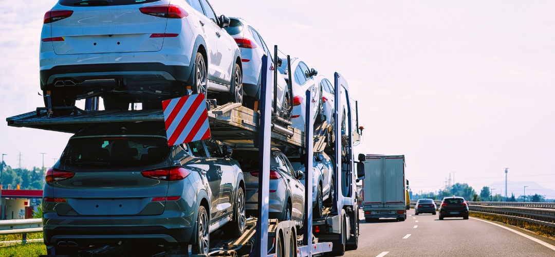 A multi-car carrier trailer loaded with several SUVs
