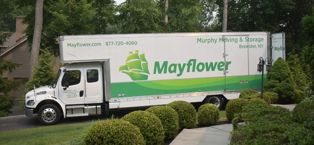 a moving and storage truck parked on a residential driveway