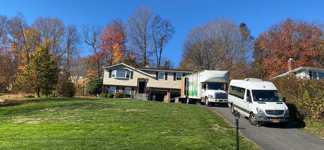 a moving truck and a passenger van parked on a driveway