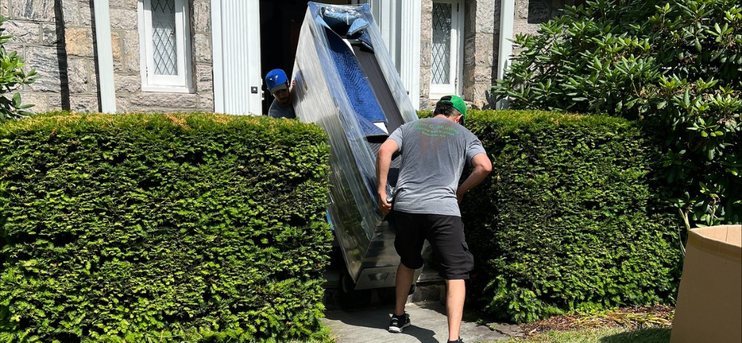 Two movers navigate a large piece of furniture