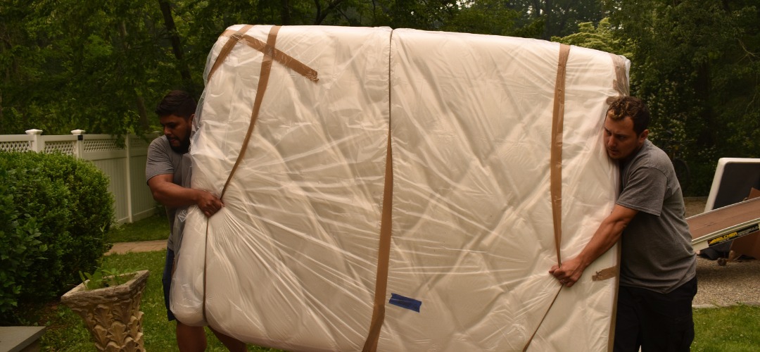 movers carrying a large mattress
