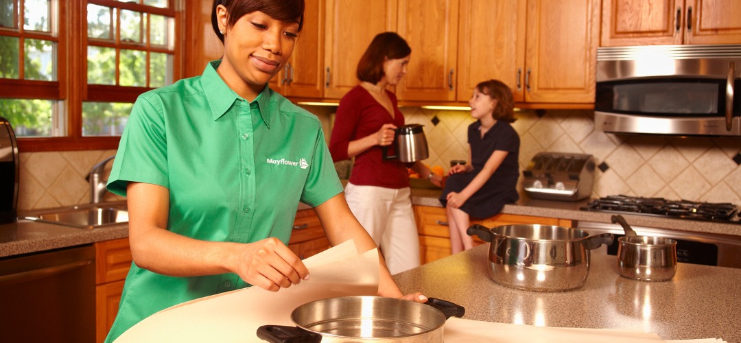A Mayflower mover wrapping kitchen pots