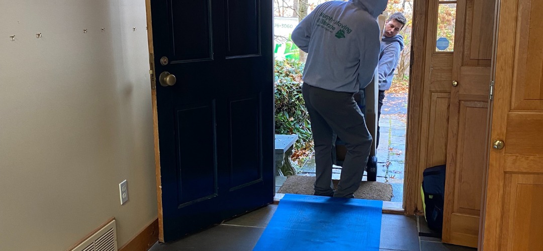 Two movers using a dolly to navigate a large item