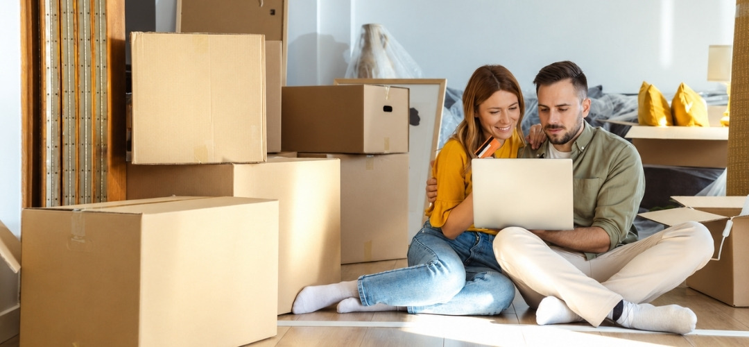man and woman sit cross-legged on the floor of a new apartment
